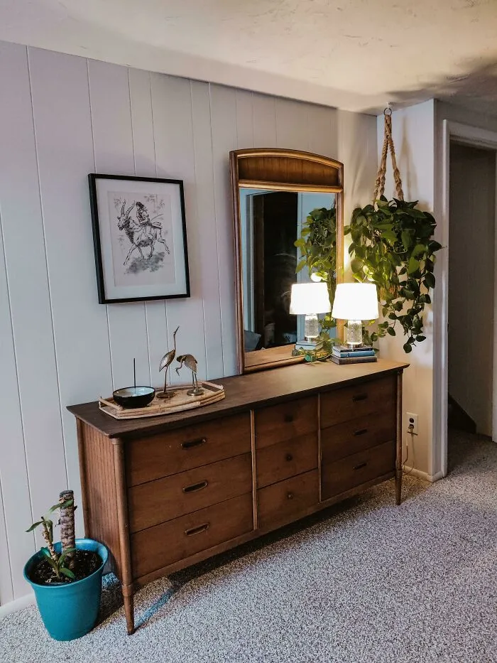 Wooden nightstand with mirror and a plant 