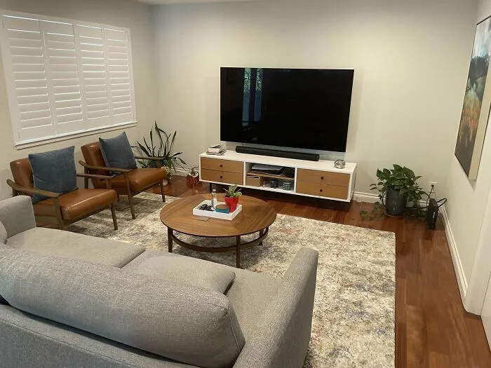 White living room with the grey couch and leather chairs 