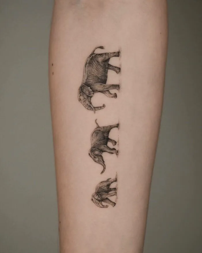 Tattoo of a family of elephants on skin, symbolizing unbreakable bonds.