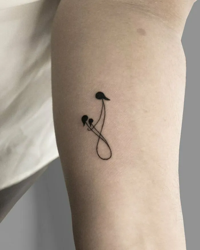 Minimalistic family tattoo symbolizing unbreakable bonds on inner arm.