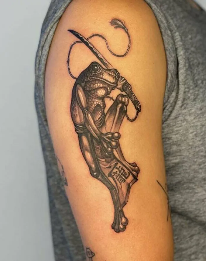 Frog tattoo design on upper arm symbolizing family bonds.