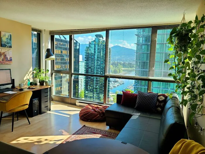 Living room with black couch and big windows 