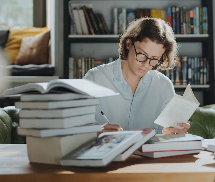 Man Reading Books And Taking Notes