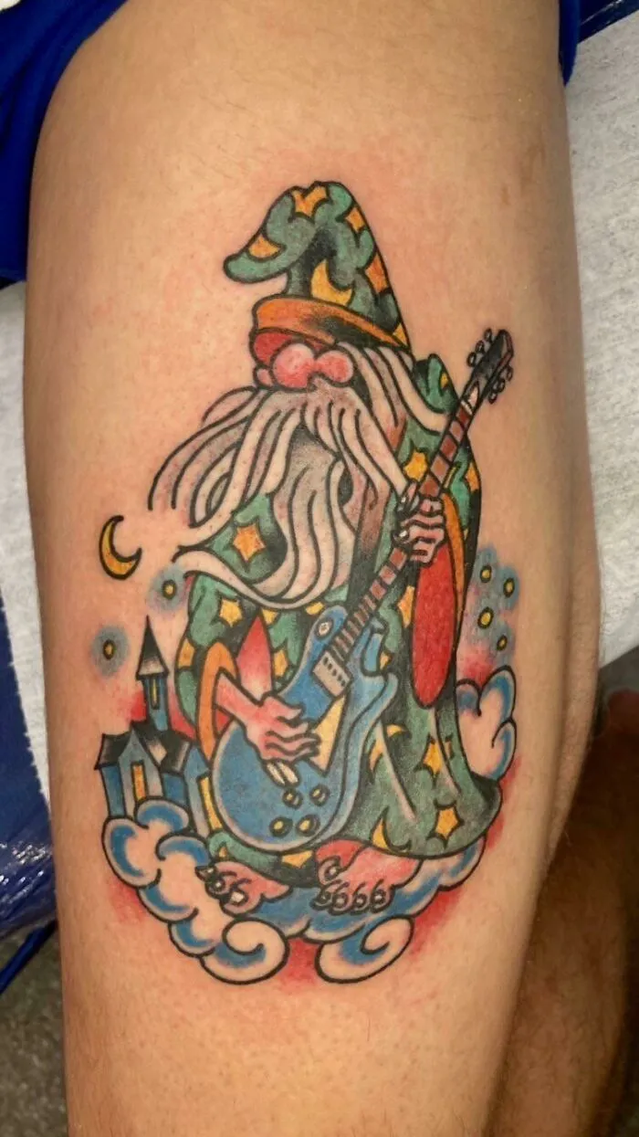 Colorful American traditional tattoo of a wizard with a guitar.