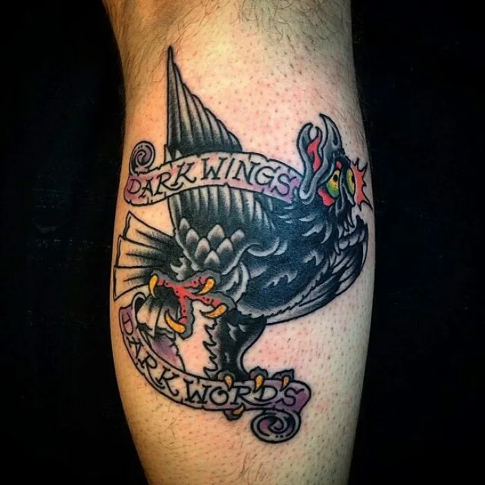 American traditional tattoo of a black crow with banners reading "Dark Wings Dark Words."
