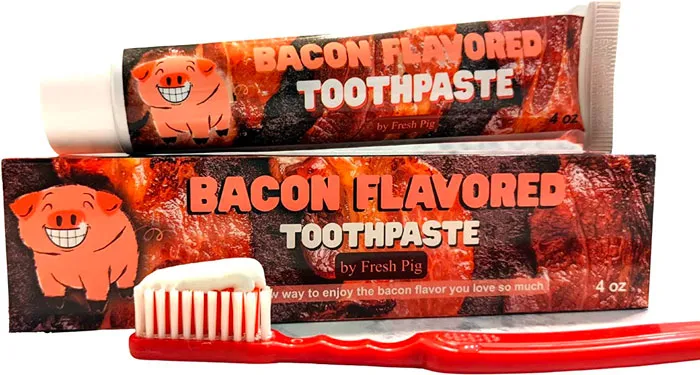 a red toothbrush with toothpaste on it near the package with toothpaste