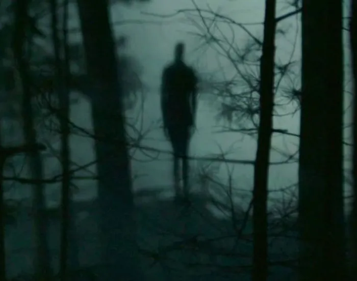 Slenderman standing in the dark forest 