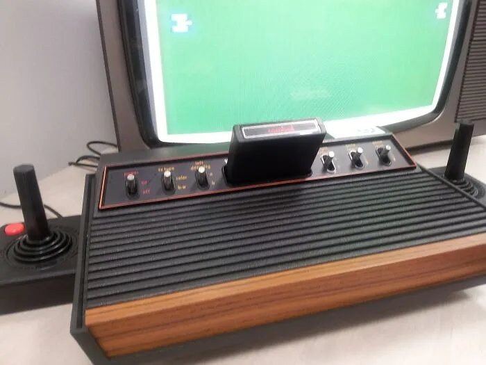 Vintage gaming console with joystick and cartridge, showcasing iconic old gadgets that were the trendsetters of their time.