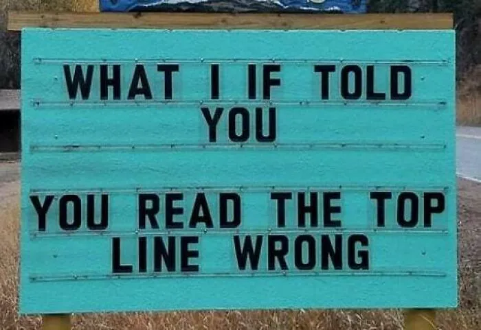 A funny sign reads, "WHAT I IF TOLD YOU, YOU READ THE TOP LINE WRONG" on a turquoise background.