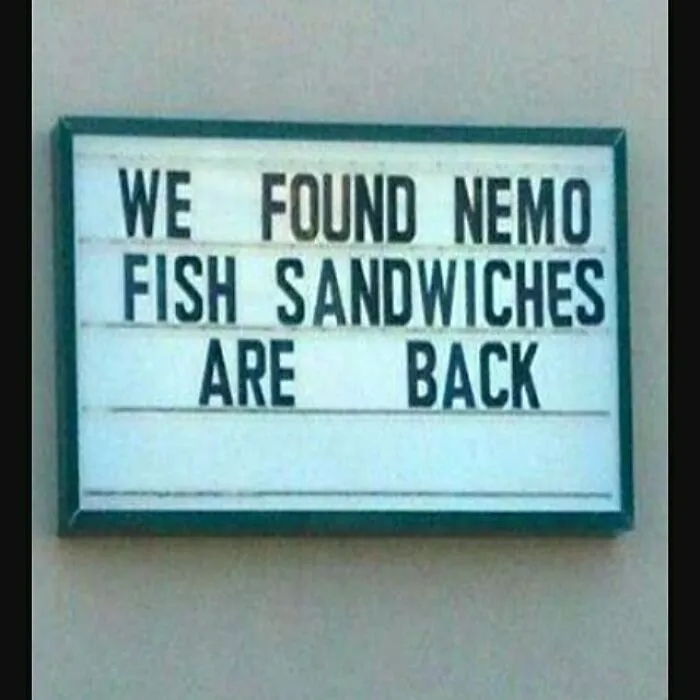 Funny sign reads, "We found Nemo. Fish sandwiches are back," humorously announcing a menu item return.