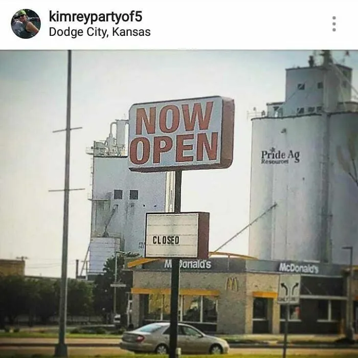Funny sign with contrasting messages: "Now Open" and "Closed" outside a McDonald's in Dodge City, Kansas.