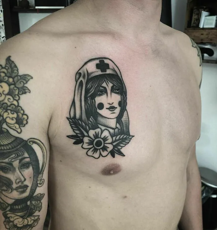 American traditional tattoo of a nurse with a flower on a man's chest.