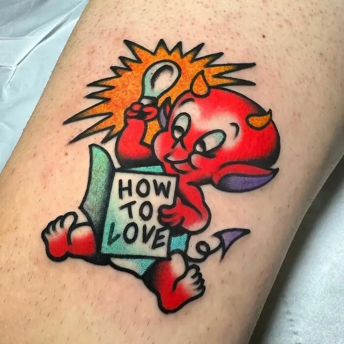 American traditional tattoo of a cute red devil holding a "How to Love" book on skin.