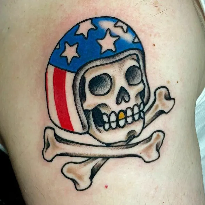 American traditional tattoo of a skull and crossbones wearing a patriotic helmet.