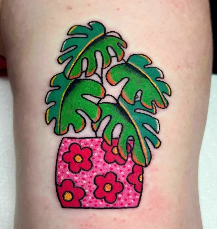 American traditional tattoo of green leaves in a pink floral pot.