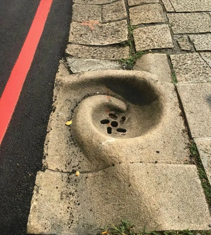 Drenaje dirigido por la corriente de agua en una pendiente pronunciada en Taiwán. Casi como una escultura callejera intencionada