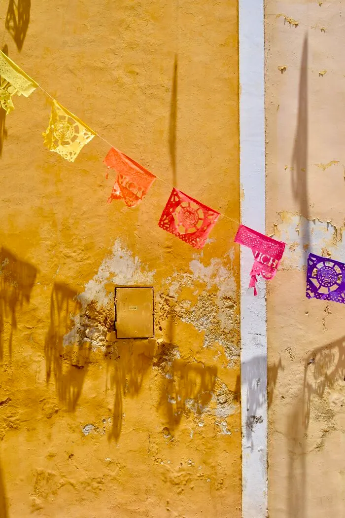Papel Picado Against A Yellow Wall In Izamal, Yucatan