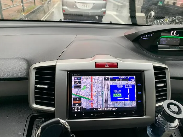 Car dashboard featuring an old gadget GPS navigation system displaying a detailed map and directions on the screen.