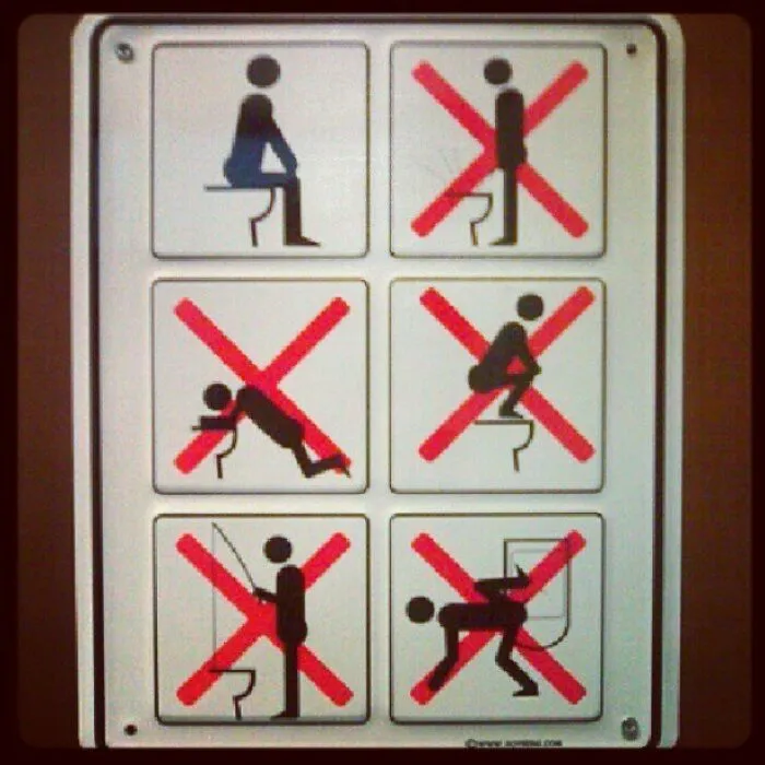 Funny restroom sign showing incorrect ways to use a toilet.