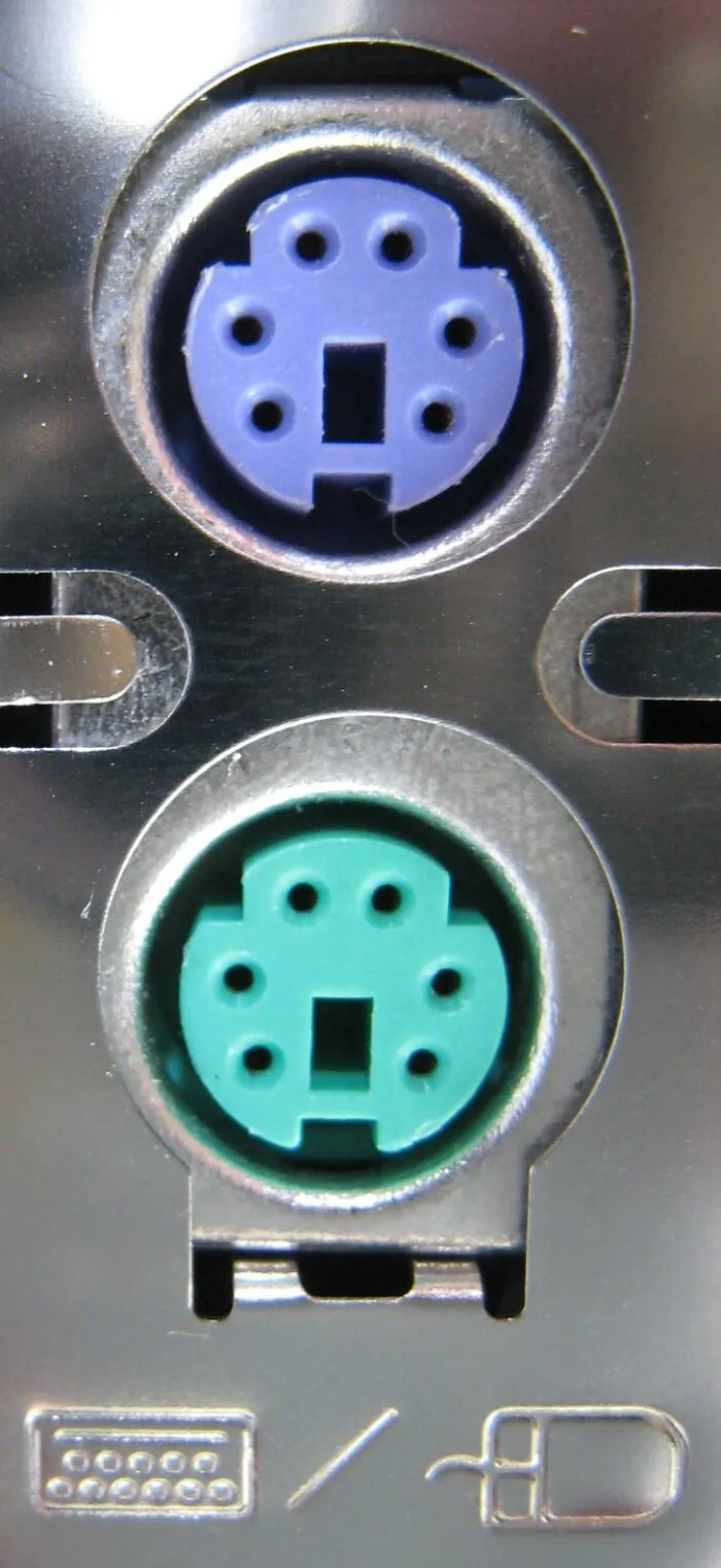 Close-up of old gadgets PS/2 keyboard and mouse ports on a computer back panel, showing vintage technology connectors.