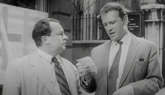 Petter holding piece of paper and talking with Bill
