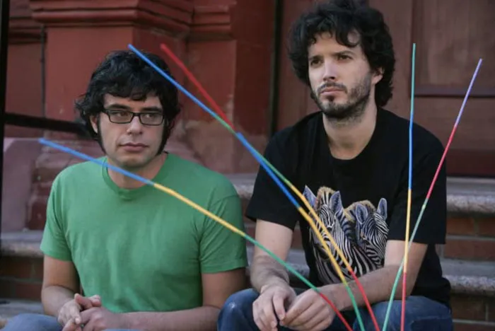 Two man with a lot of hair sitting 