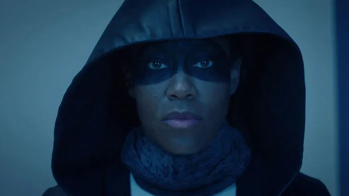 Woman with a hoodie and painted face in a dark place 