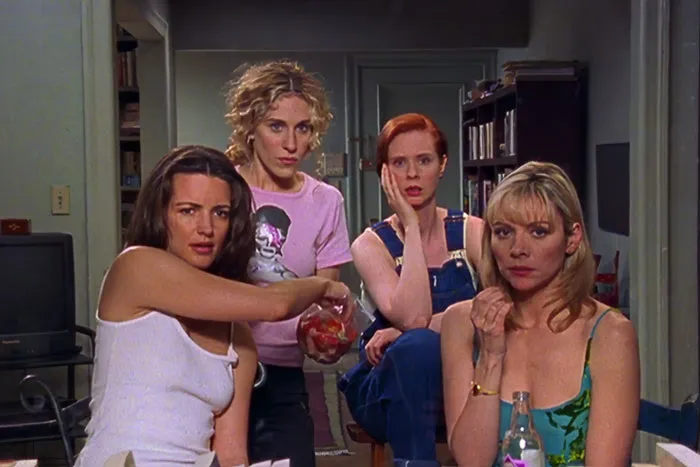 Four woman watching at something and eating 
