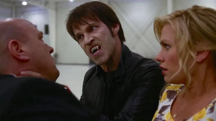 Scared woman looking at the Vampire who is scaring a man 