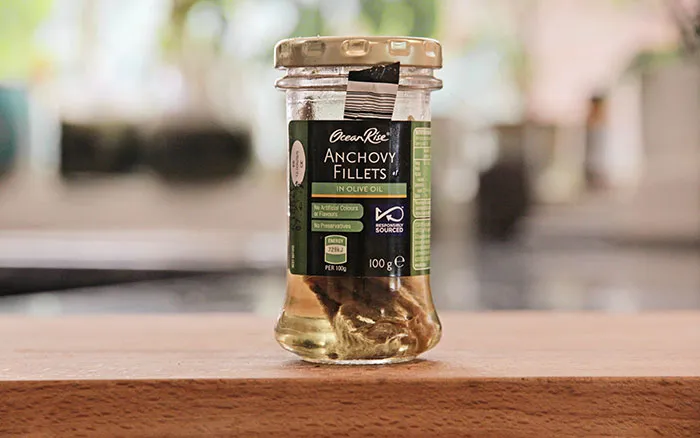 A jar of pickles sitting on top of a wooden table