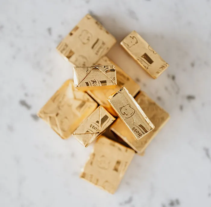 Broth cubes in golden wrappers on table