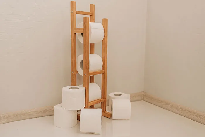 White toilet paper rolls on brown wooden rack