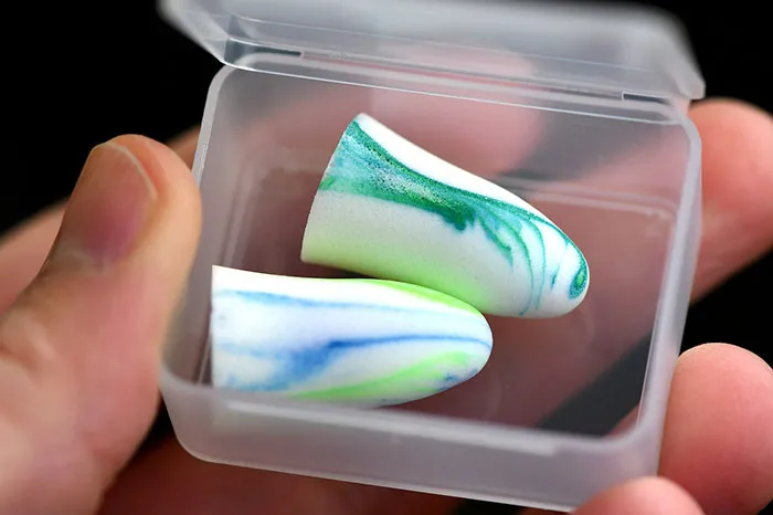 Man holding ear plugs in the plastic box