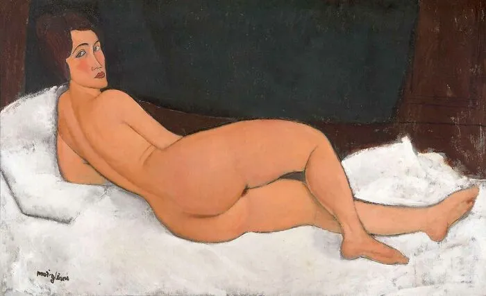 Reclining nude (on the left side) by Amedeo Modigliani, 1917, oil painting features naked woman reclining on a couch