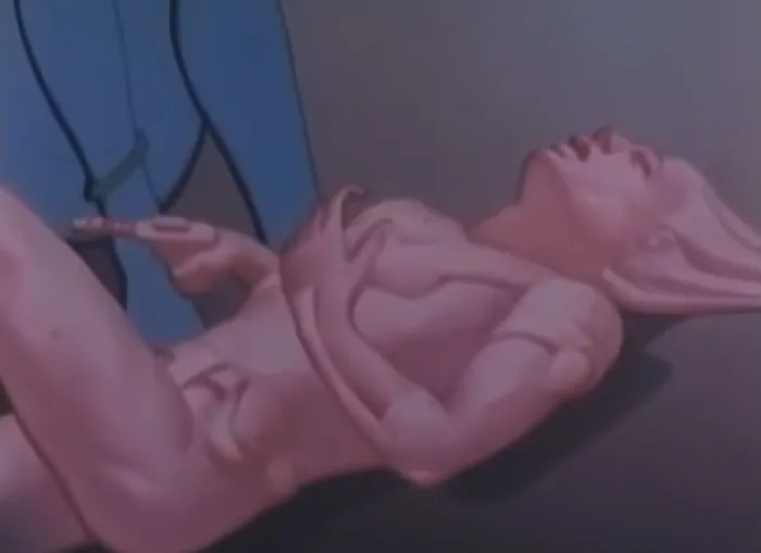 Image from Mystery Skulls "Be With You" & "Invincible" music video - a pink cyber woman with an open mouth and gun in her hands lying down