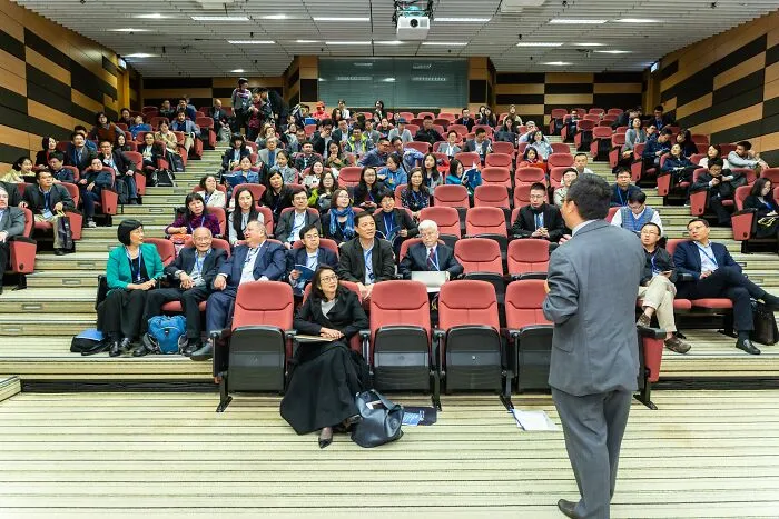 A man giving a speech to multiple other people  