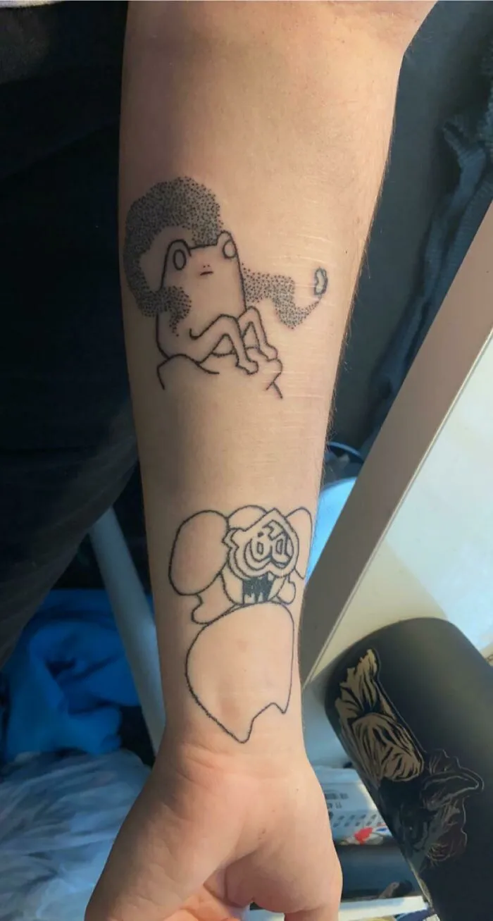 Arm displaying wrist tattoo designs, featuring unique abstract characters, part of diverse tattoo art styles.