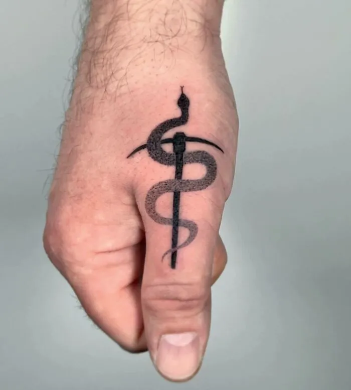 Snake tattoo on the hand blending minimalism and symbolism for unique small hand tattoos.