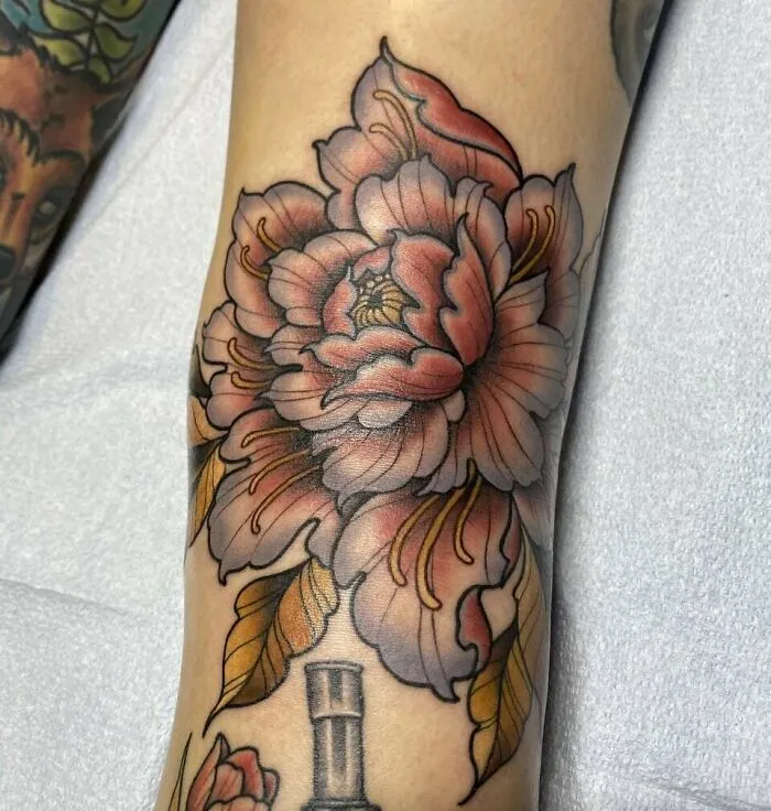 Knee tattoo showcasing a vibrant floral design with intricate shading and colors.