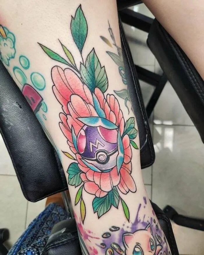 Colorful knee tattoo featuring a floral design with a pokeball element.