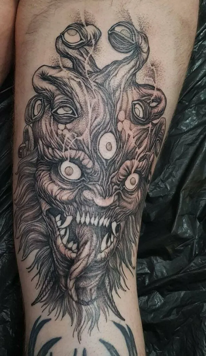 Intricate monster-themed knee tattoo design showcasing detailed linework and textures.