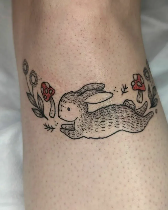 Rabbit and floral knee tattoo design featuring mushrooms and flowers.