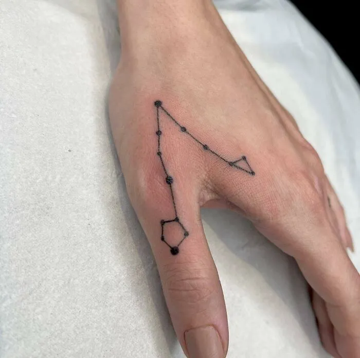 Constellation small hand tattoo design on the back of a hand.