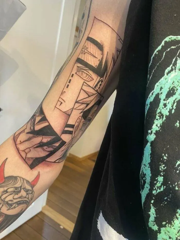 Arm with anime tattoos featuring detailed character designs, showcasing intricate line work and vibrant artistic style.