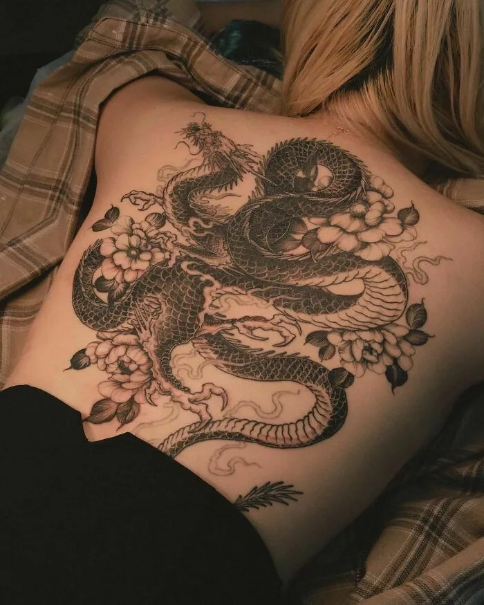 Black Ink Dragon Tattoo With Floral Designs On The Back