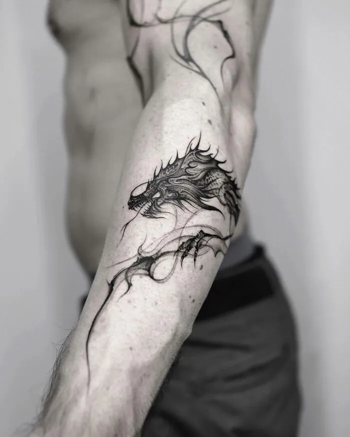 Dragon tattoo design on forearm, showcasing intricate details and fierce expression, perfect for inspiration.