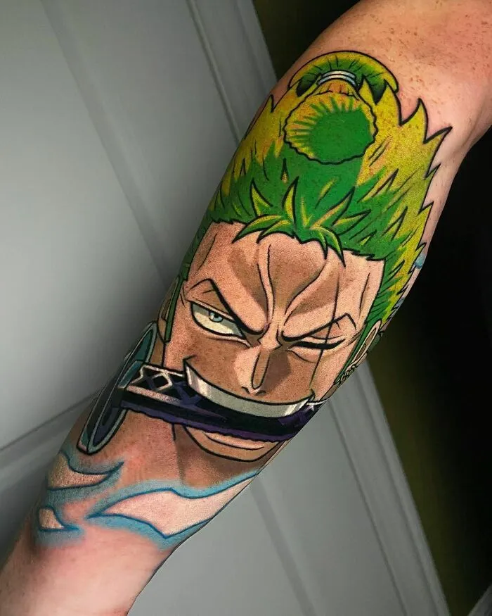 Anime tattoo of a character with green hair and a sword in his mouth on an arm.