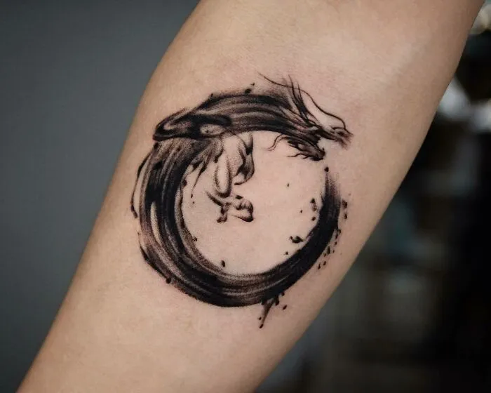 Abstract dragon tattoo design on forearm, featuring a circular brushstroke style.