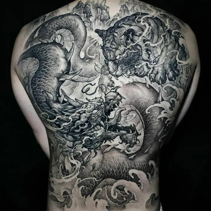 Intricate dragon tattoo on a person's back, featuring detailed scales and a dynamic design.