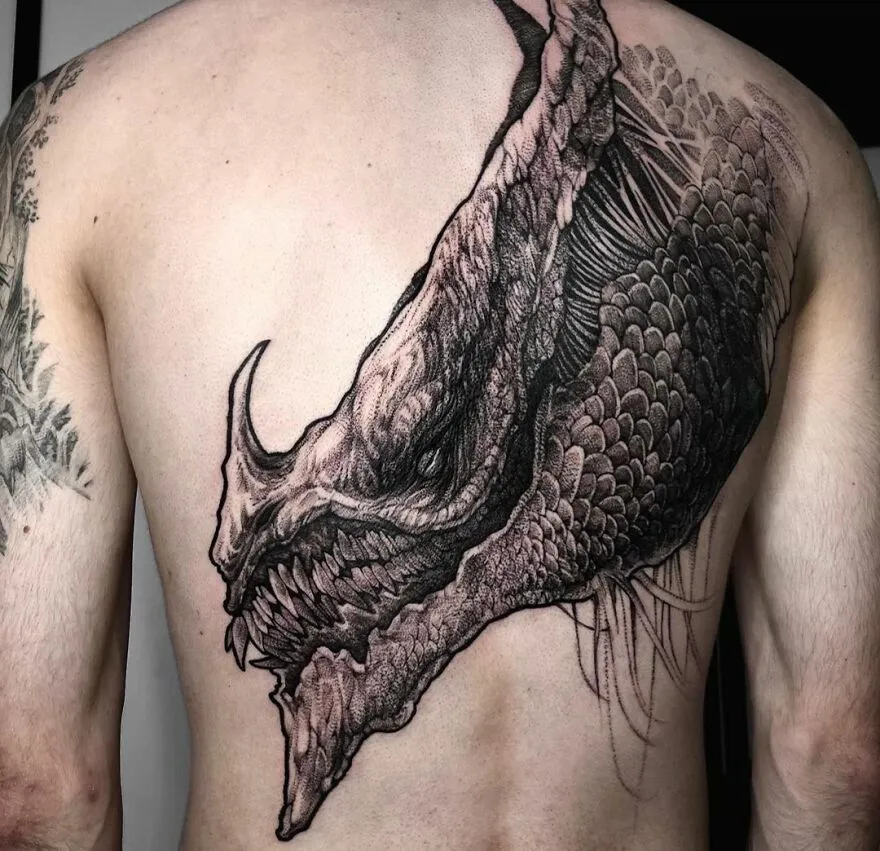 Detailed dragon tattoo covering a man's back, showcasing intricate scales and fierce expression.